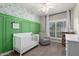 A stylish Bedroom featuring a white crib, chair, green accent wall, and floral wallpaper at 6577 W Abraham Ln, Glendale, AZ 85308