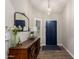 Stylish entryway features wood-look floors, a modern light fixture, and a dark blue front door at 6577 W Abraham Ln, Glendale, AZ 85308