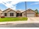 Charming single-story home with a well-manicured lawn, desert landscaping, and a two-car garage at 6577 W Abraham Ln, Glendale, AZ 85308