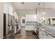 Open kitchen featuring white cabinets, granite countertops, and stainless steel appliances at 6577 W Abraham Ln, Glendale, AZ 85308