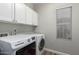 Well-lit laundry room with white cabinets, Maytag washer and dryer, and wood-look flooring at 6577 W Abraham Ln, Glendale, AZ 85308