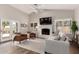 Bright living room features a brick fireplace, neutral color palette, and outdoor access at 6577 W Abraham Ln, Glendale, AZ 85308