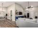 Open-concept living space featuring wood-look flooring, a stylish sectional sofa, and ample natural light at 6577 W Abraham Ln, Glendale, AZ 85308