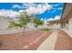 Landscaped backyard with stone pathway and partially covered patio area at 8516 W Saint John Rd, Peoria, AZ 85382