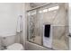 Well-lit bathroom featuring a toilet and a shower with decorative tile and sliding glass doors at 8516 W Saint John Rd, Peoria, AZ 85382