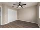 Simple bedroom featuring wood flooring, neutral walls, closet and a modern ceiling fan at 8516 W Saint John Rd, Peoria, AZ 85382