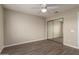 Neutral bedroom featuring a mirrored closet, wood floor and a modern ceiling fan at 8516 W Saint John Rd, Peoria, AZ 85382