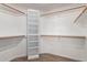 Spacious walk-in closet with built-in shelving, wood floor and rod to hang clothing at 8516 W Saint John Rd, Peoria, AZ 85382