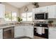 Close-up of the modern kitchen featuring stainless appliances, granite counters, and lots of natural light at 8516 W Saint John Rd, Peoria, AZ 85382