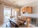 Bright dining room with rustic wooden table, outdoor access, and built-in cabinets with a beverage cooler at 8703 E Nora St, Mesa, AZ 85207