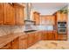 Gourmet kitchen with custom wood cabinets, granite countertops, and stainless steel appliances at 8703 E Nora St, Mesa, AZ 85207