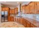 Well-equipped kitchen featuring wood cabinets, granite countertops, and stainless steel appliances at 8703 E Nora St, Mesa, AZ 85207