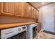 Spacious laundry room with ample cabinets, counter space, and modern appliances at 8703 E Nora St, Mesa, AZ 85207