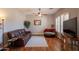 Cozy living room with a leather sofa, hardwood floors, and a ceiling fan at 8703 E Nora St, Mesa, AZ 85207