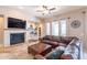 Spacious living room with a fireplace, built-in shelves, and a comfortable leather couch at 8703 E Nora St, Mesa, AZ 85207