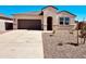 Single-story home with desert landscaping, a gray garage door, and a covered front entryway at 11946 E Cliffrose Ln, Florence, AZ 85132