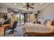 Bedroom featuring neutral tones, a desk, a ceiling fan, and balcony access with verdant backyard views at 12240 S Honah Lee Ct, Phoenix, AZ 85044