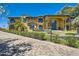 Elegant two-story home showcasing a yellow exterior with a blue door, stone accents, and meticulously landscaped grounds at 12240 S Honah Lee Ct, Phoenix, AZ 85044