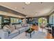 Spacious living room featuring hardwood floors, a large sectional sofa, and access to the home's exterior at 12240 S Honah Lee Ct, Phoenix, AZ 85044