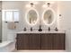 Bathroom featuring double sinks with quartz counters, decorative lighting and clean white walls at 2178 E La Jolla Dr, Tempe, AZ 85282