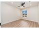 Bright bedroom with light wood floors, ceiling fan, and window with street view at 2178 E La Jolla Dr, Tempe, AZ 85282