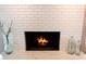Close-up of a white brick fireplace with a marble hearth and elegant glass decorative vases at 2178 E La Jolla Dr, Tempe, AZ 85282