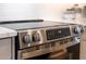 Close-up of stainless steel stove in modern kitchen with stone countertop and backsplash at 2178 E La Jolla Dr, Tempe, AZ 85282
