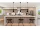 Modern kitchen featuring a large island with a quartz countertop, pendant lights, and stainless steel appliances at 2178 E La Jolla Dr, Tempe, AZ 85282