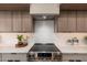 Contemporary kitchen features stainless steel range and hood, complemented by sleek countertops and modern cabinetry at 2178 E La Jolla Dr, Tempe, AZ 85282