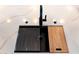 Modern kitchen sink with stone countertops and complementary wood cutting board at 2178 E La Jolla Dr, Tempe, AZ 85282