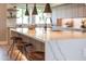 Kitchen island has barstool seating and quartz countertop, creating an inviting and functional space at 2178 E La Jolla Dr, Tempe, AZ 85282