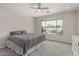 This bedroom features a ceiling fan and a large window overlooking the backyard pool area at 21840 N 260Th Ln, Buckeye, AZ 85396