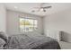 This bedroom features a ceiling fan and a large window overlooking the backyard pool area at 21840 N 260Th Ln, Buckeye, AZ 85396