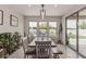 Bright dining room with a wooden table, bench, and chairs, illuminated by modern pendant lighting at 21840 N 260Th Ln, Buckeye, AZ 85396