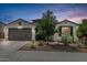 Charming single-story home featuring a two-car garage and desert landscaping at dusk at 21840 N 260Th Ln, Buckeye, AZ 85396
