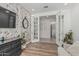 Bright living room featuring a brick accent wall, wood-like floors, and open doorway at 21840 N 260Th Ln, Buckeye, AZ 85396