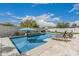 Inviting pool with lounging area, blue umbrella, and lush backyard landscaping at 21840 N 260Th Ln, Buckeye, AZ 85396