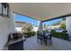 Covered patio with outdoor dining and barbecue area overlooking the pool and lush backyard at 2308 E State Ave, Phoenix, AZ 85020