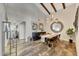 Dining room with wood floors, exposed ceiling beams, modern light fixture, and round mirror at 2308 E State Ave, Phoenix, AZ 85020