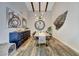 Dining room with wood floors, exposed ceiling beams, modern light fixture, and round mirror at 2308 E State Ave, Phoenix, AZ 85020