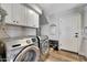 Laundry room featuring modern washer and dryer units and white storage cabinets at 2308 E State Ave, Phoenix, AZ 85020