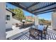 Inviting outdoor patio featuring a dining table, fireplace, lounge seating, and shade structure at 2308 E State Ave, Phoenix, AZ 85020
