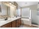 Bathroom with double sinks, decorative tile, glass block window and bathtub at 4554 S Cobblestone St, Gilbert, AZ 85297