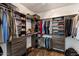 Spacious walk-in closet with custom shelving, drawers, and ample storage for clothing and accessories at 4554 S Cobblestone St, Gilbert, AZ 85297