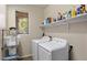 Laundry room with modern appliances, shelving, and a window at 4554 S Cobblestone St, Gilbert, AZ 85297
