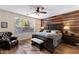 Serene main bedroom with wood accent wall, ceiling fan, and natural light at 4554 S Cobblestone St, Gilbert, AZ 85297