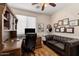 Well-lit home office featuring rich wood desk, leather sofa, and custom wall decor at 4554 S Cobblestone St, Gilbert, AZ 85297