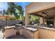 This spacious outdoor kitchen features a built-in grill and counter space for cooking and entertaining at 4554 S Cobblestone St, Gilbert, AZ 85297