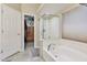 Main bathroom featuring soaking tub, shower, and walk in closet at 6102 W Shangri La Rd, Glendale, AZ 85304
