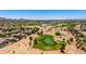 Aerial view of a desert golf community, highlighting the lush green course and nearby homes at 6557 S Classic Way, Gilbert, AZ 85298